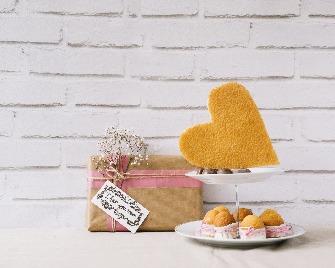 Кексы на тарелке на столе с подарком для любимой 