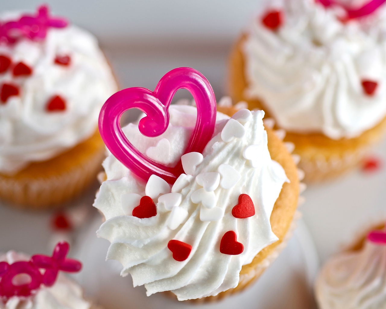Кексы с кремом и сердечками на столе 