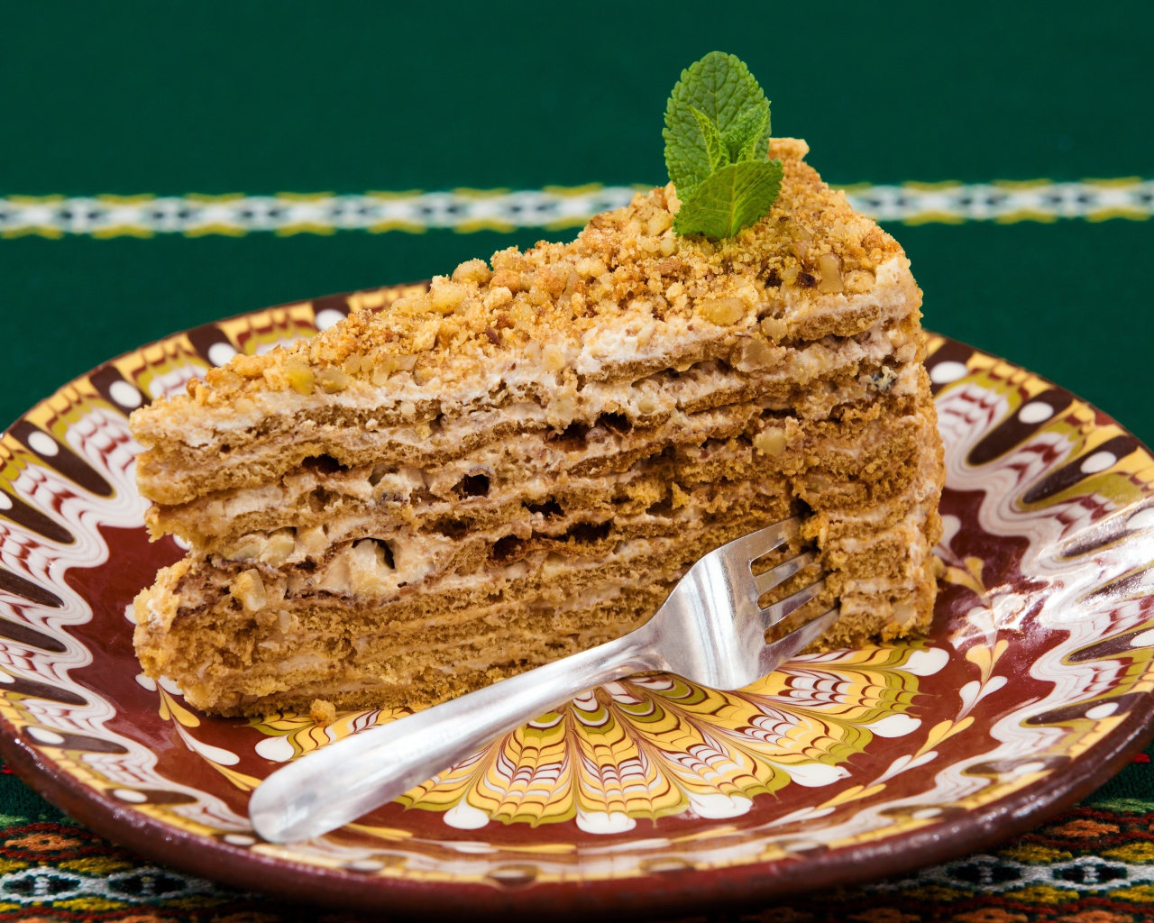 Вкусный медовый торт с орехами на красивой тарелке 