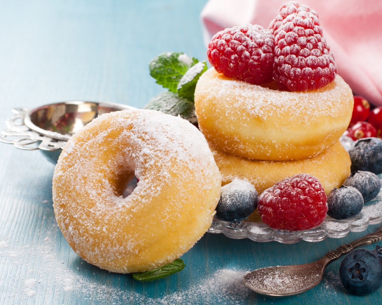 Вкусные пышные пончики с ягодами черники и малины с сахарной пудрой 