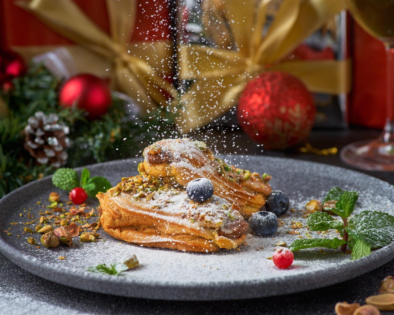 Вкусные сладкие эклеры с сахарной пудрой на блюде с ягодами 