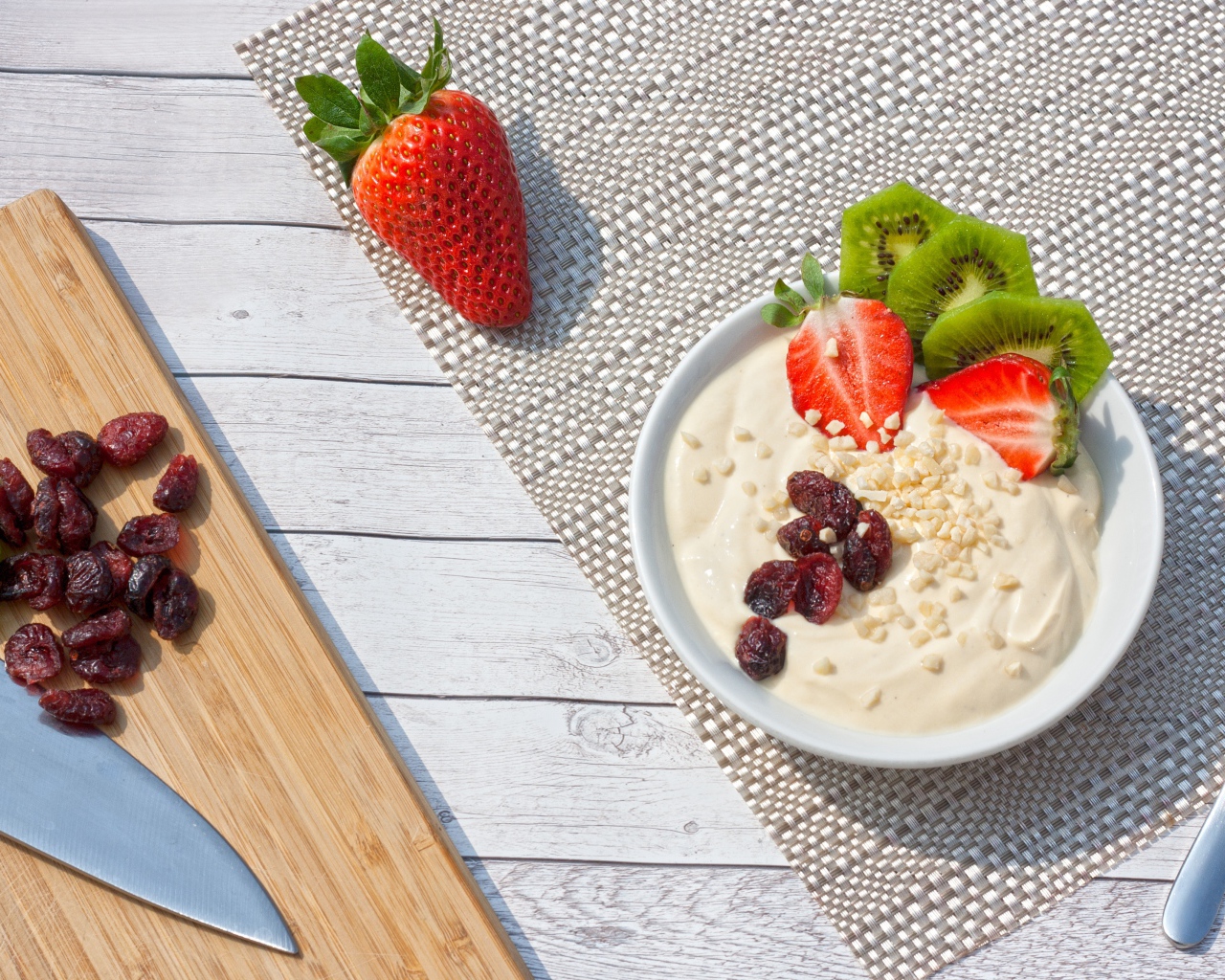 Десерт на столе с клубникой, киви и сушеной вишней