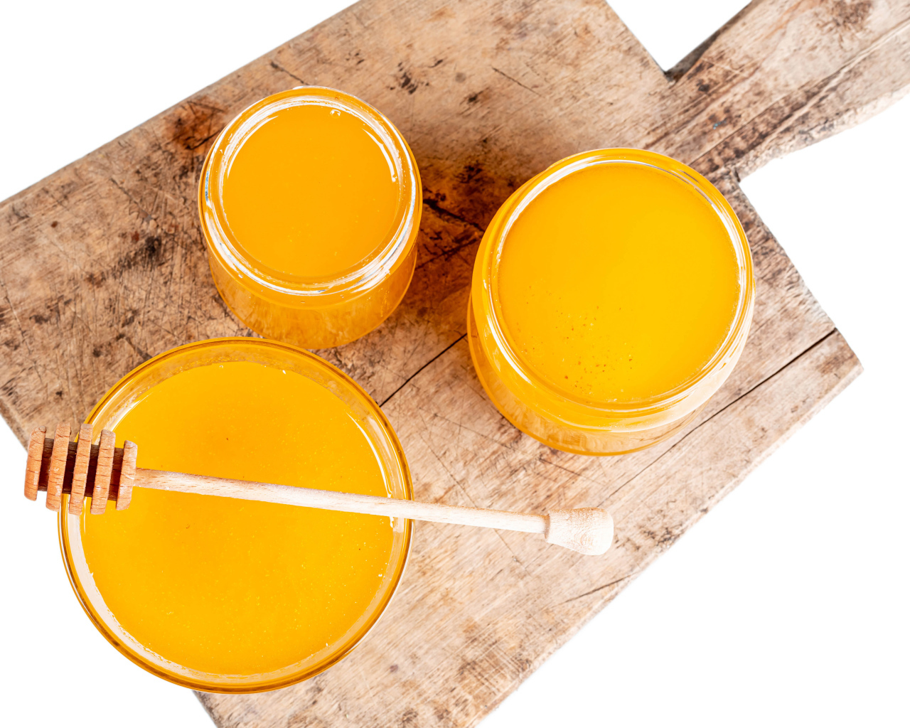 Свежий мед в банках на деревянной доске на белом фоне
