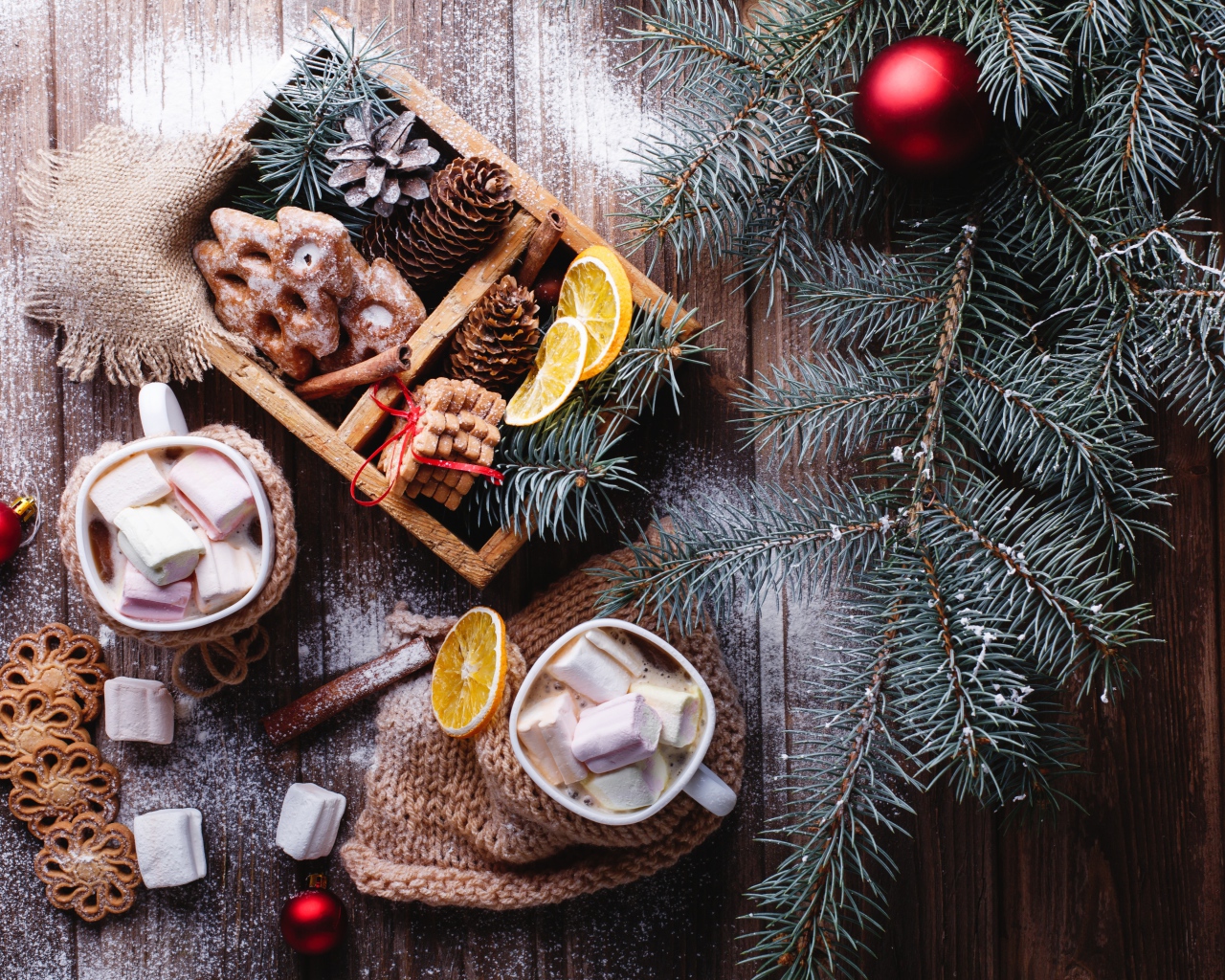 Зеленая еловая ветка на столе с печеньем и шишками