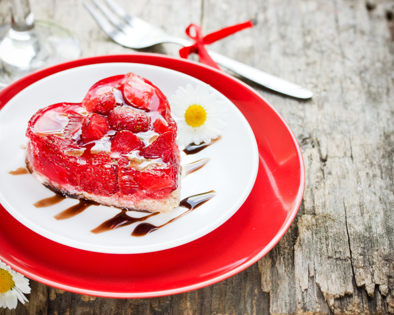 Пирожное с клубникой в форме сердца на тарелке с ромашками