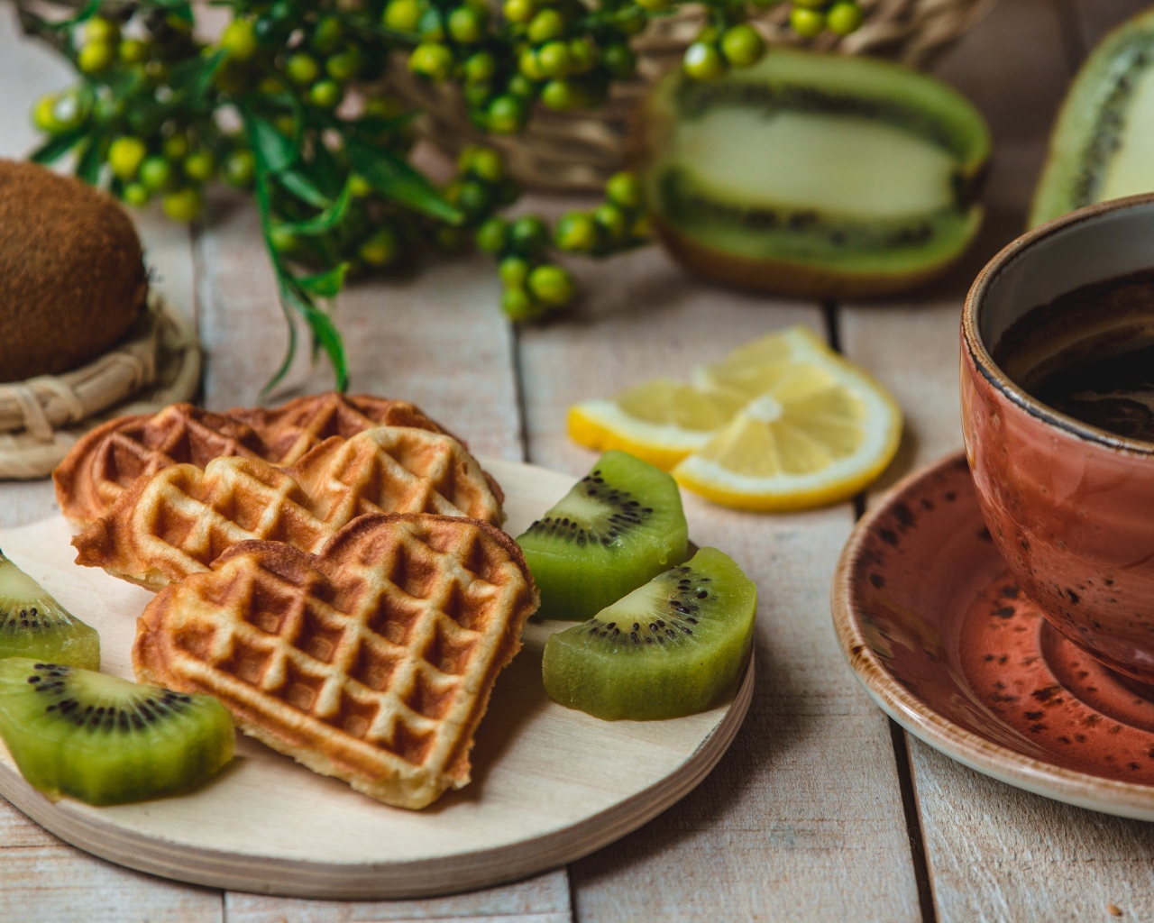 Вафли в форме сердца на доске с киви и чашкой кофе