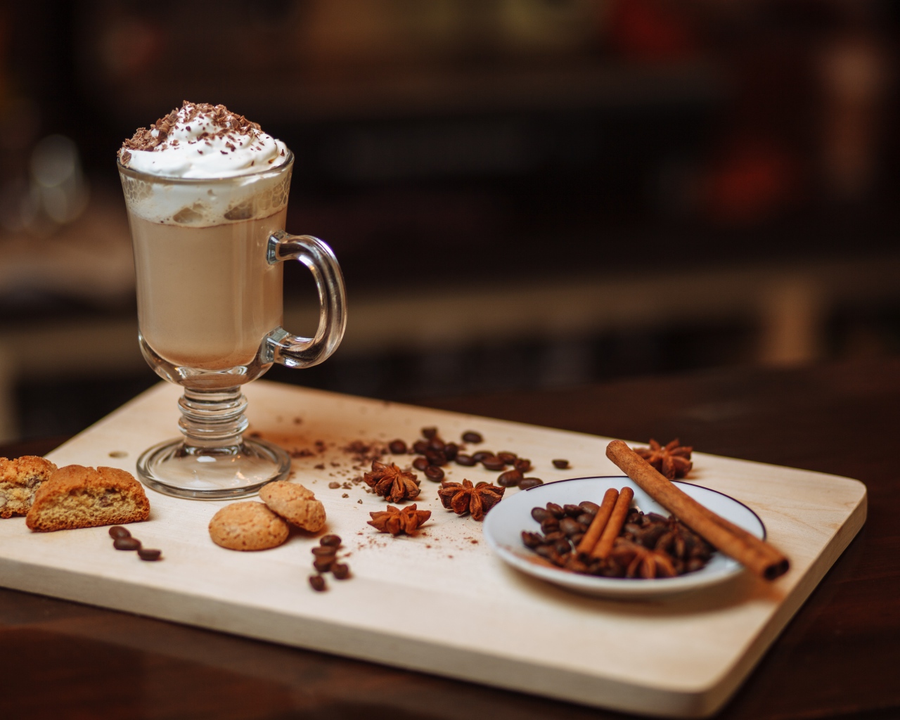 Горячее какао со сливками на столе с печеньем, зернами кофе и пряностями 