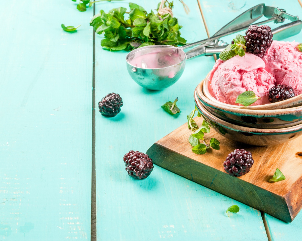 Шарики мороженого на столе с ягодами черники и мятой