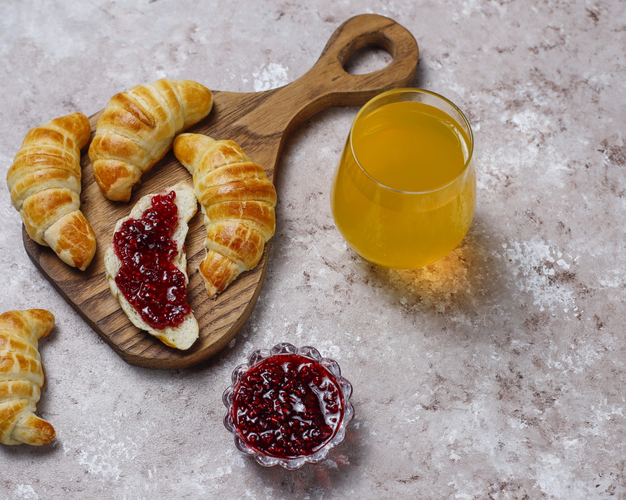 Сок на столе с круассанами и джемом