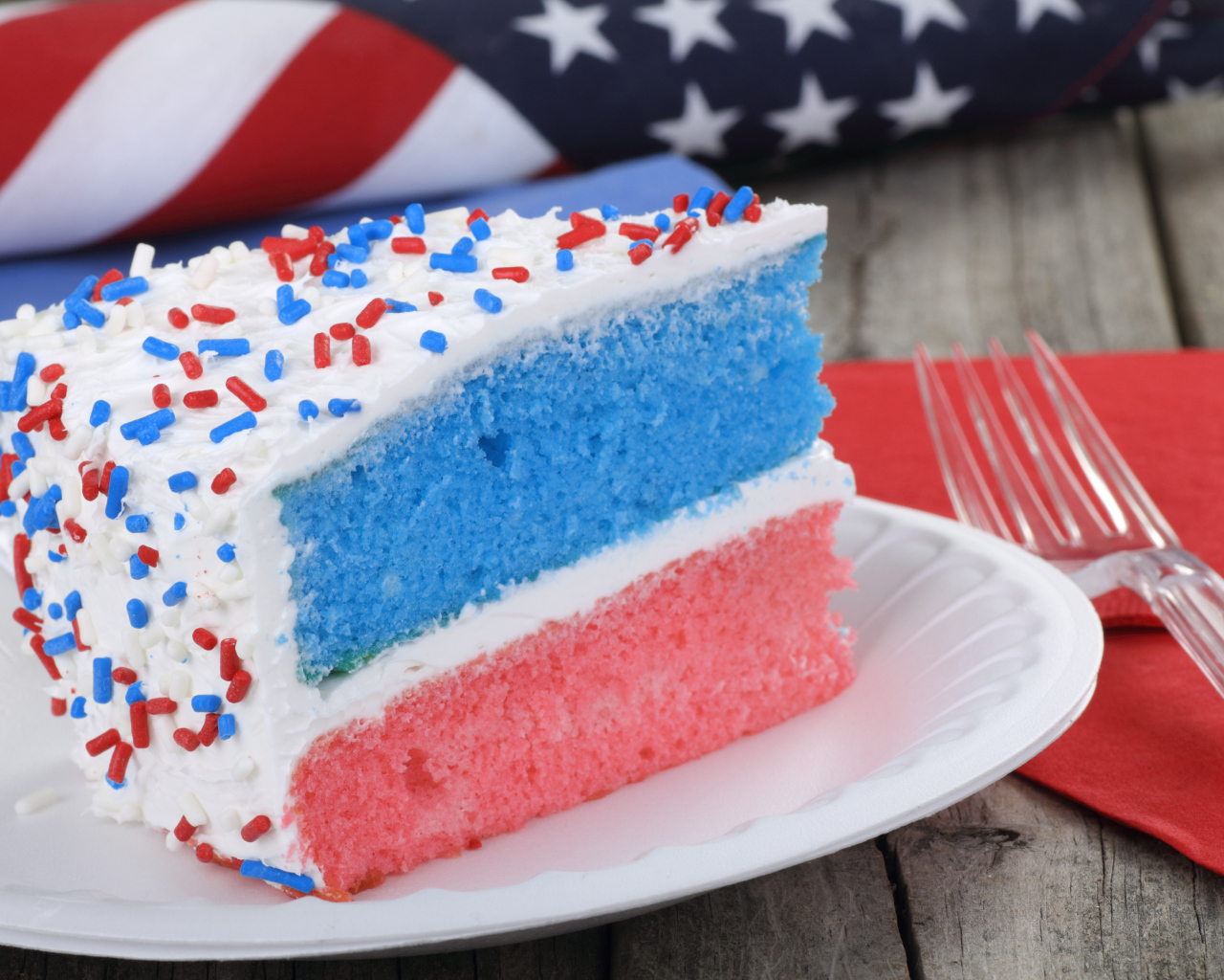 Разноцветный торт на тарелке с кремом