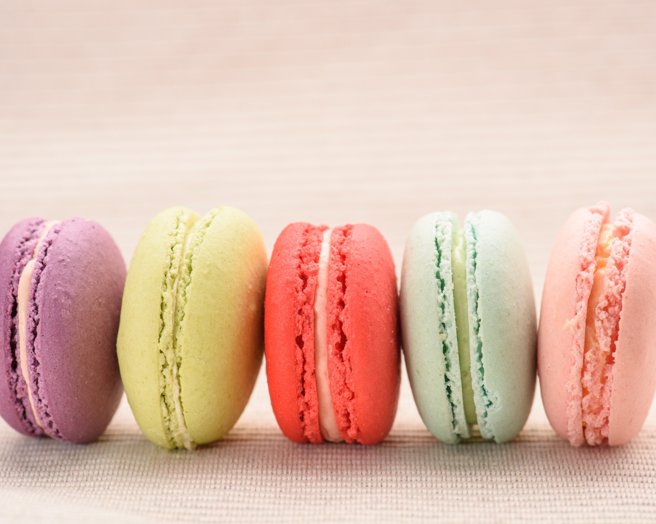 Разноцветное печенье макарон на розовом фоне 