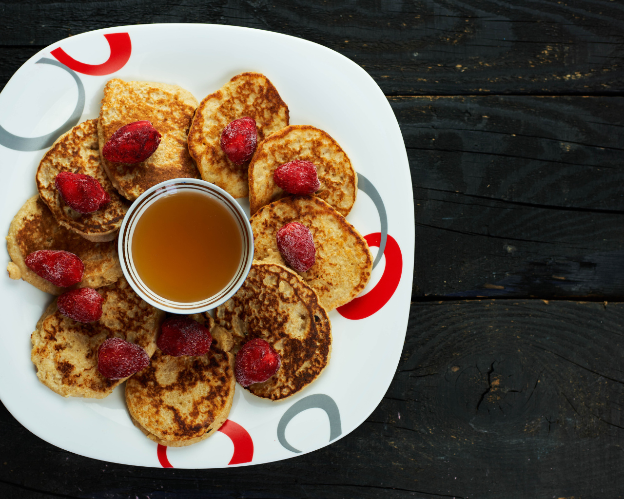 Оладьи на тарелке с клубникой и медом