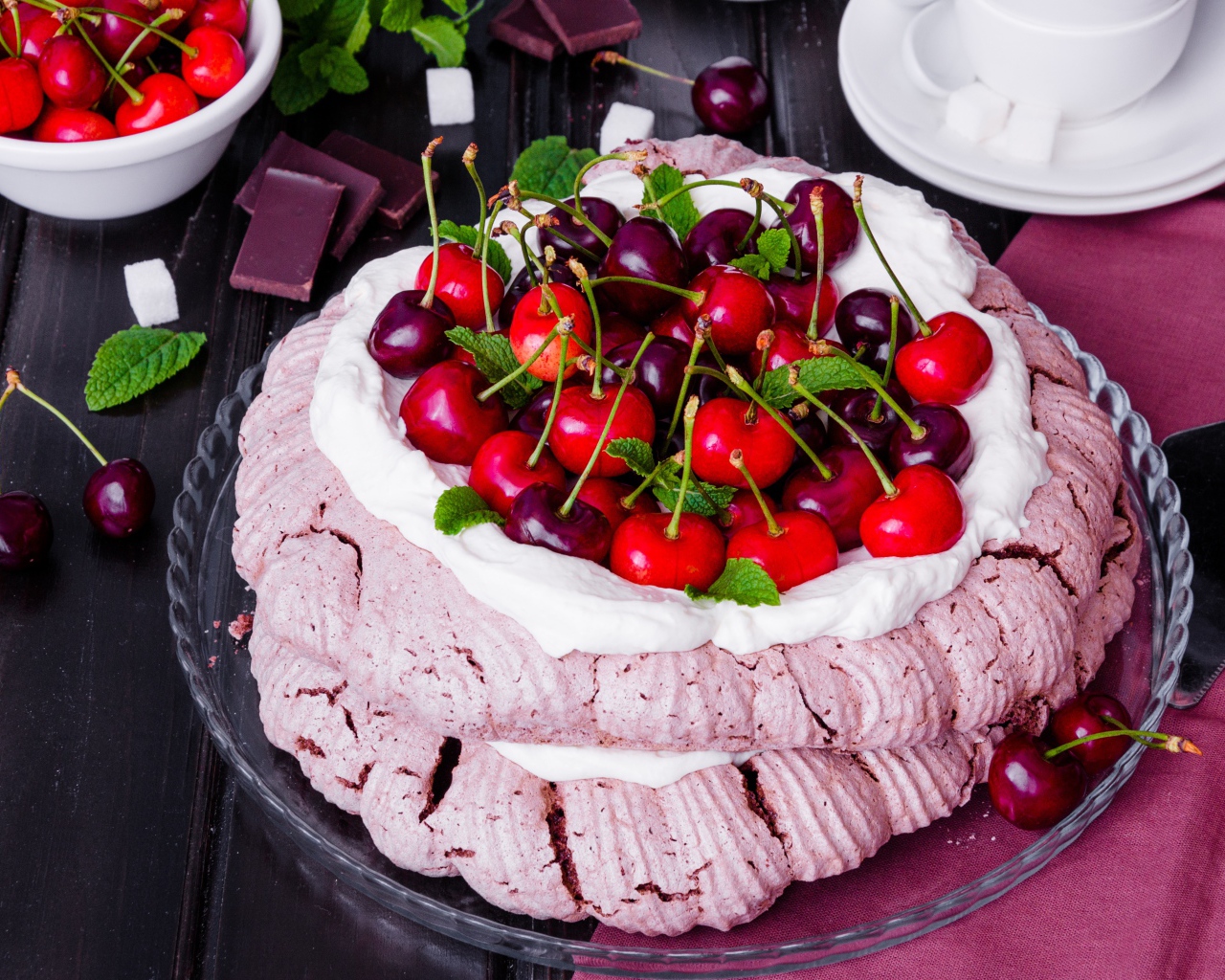 Торт Павлова со сливками и ягодами черешни на столе