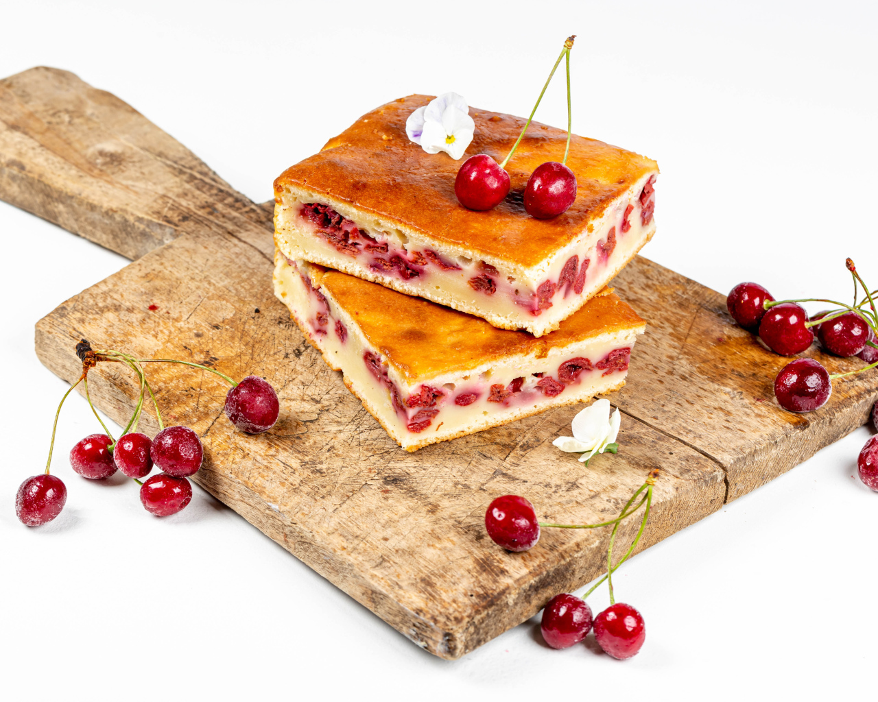 Пирог с вишнями на доске на белом фоне