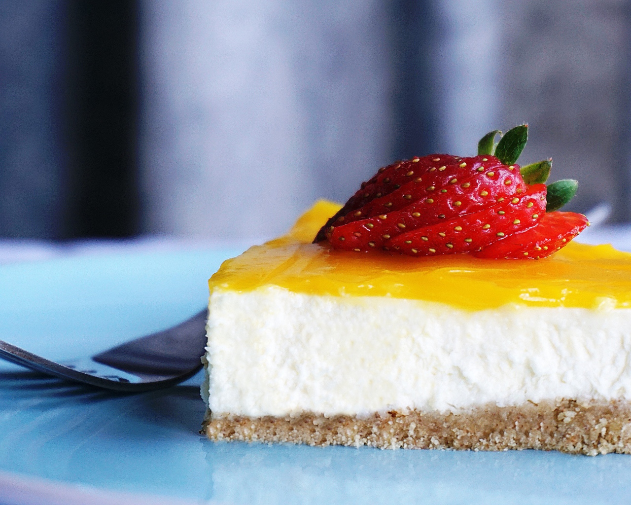 Кусок чизкейка с кремом и спелой клубникой 