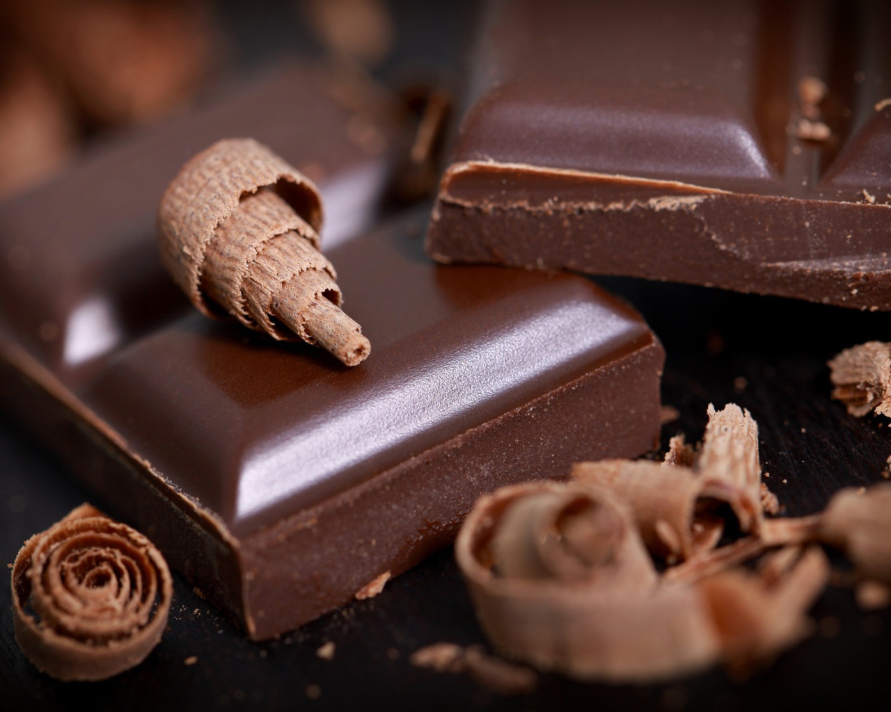 Куски шоколада и стружка на столе крупным планом