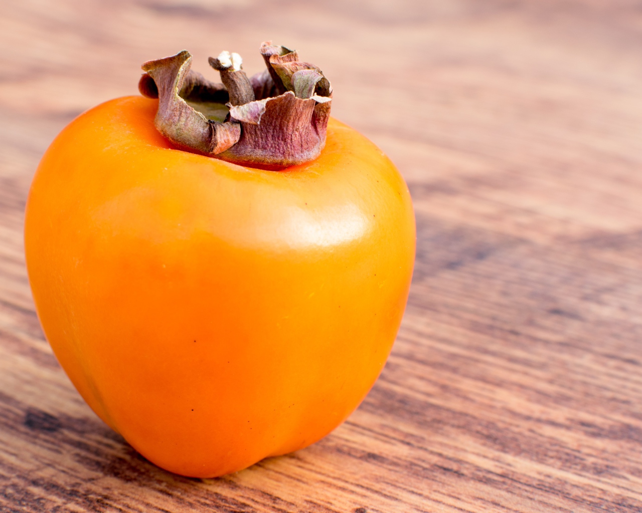 Спелая оранжевая хурма на столе