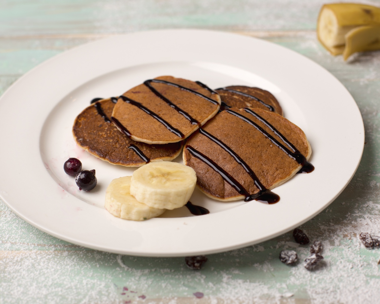 Румяные оладьи с бананом на белой тарелке 