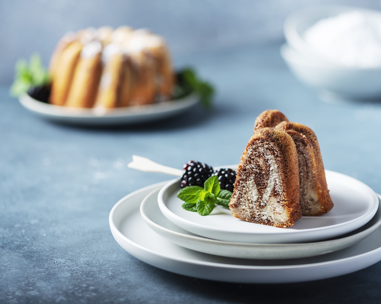 Кусочки кекса на тарелке с ягодами ежевики