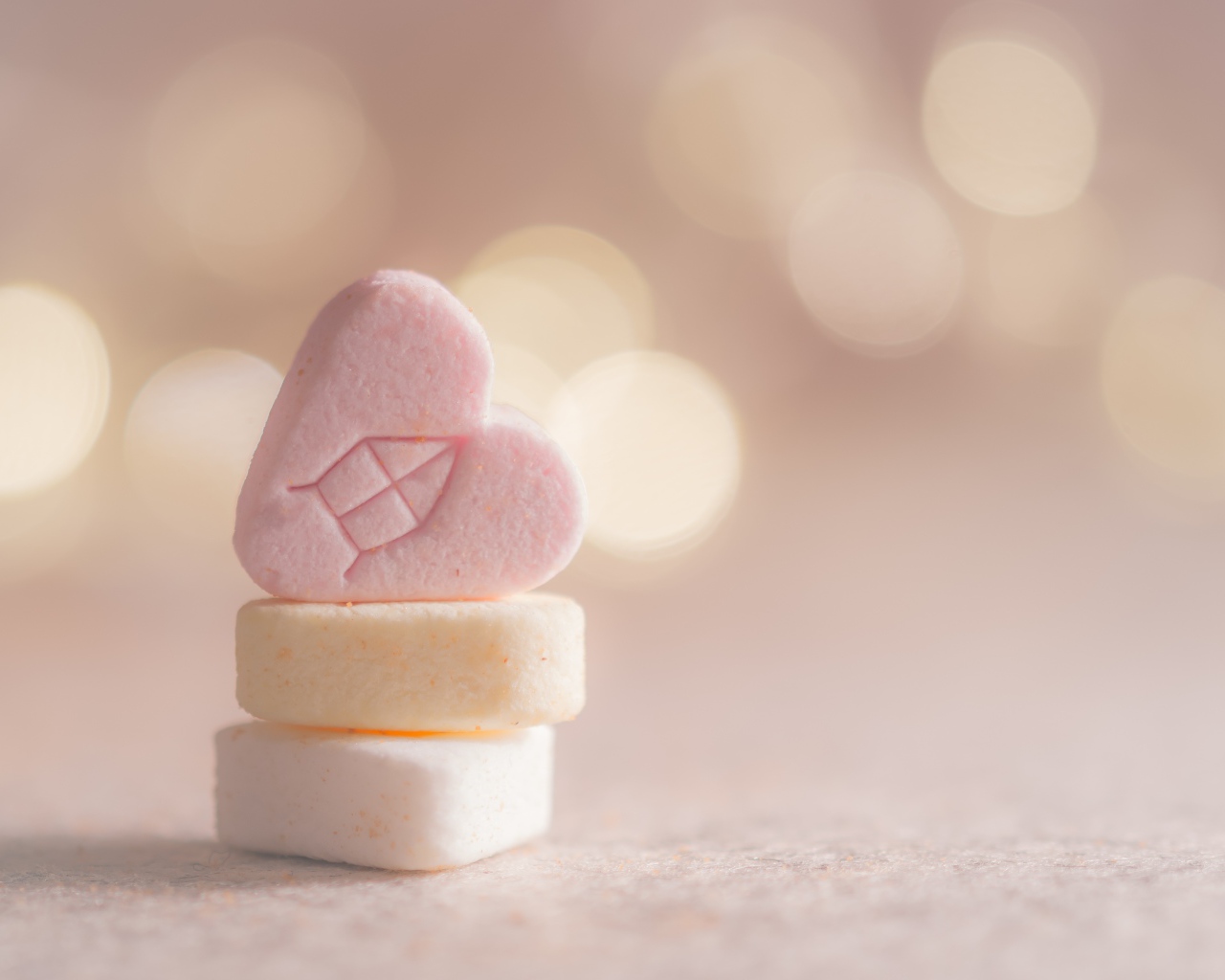 Маленькие конфеты в форме сердца на розовом фоне