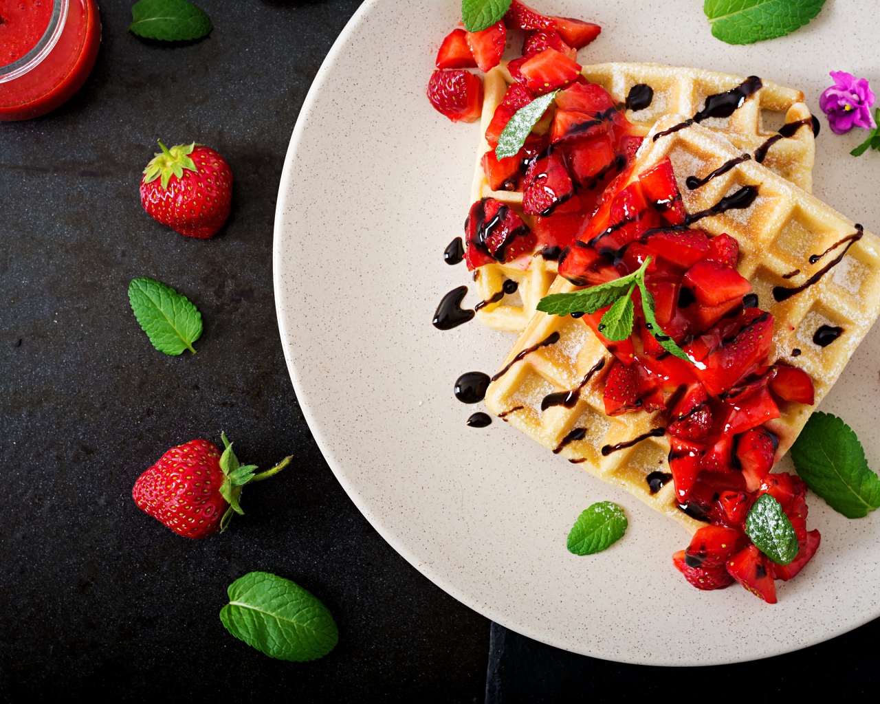 Сладкие вафли на тарелке с кусочками клубники