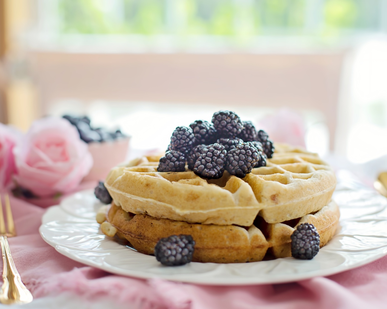 Сладкие вафли на белой тарелке с ягодами ежевики