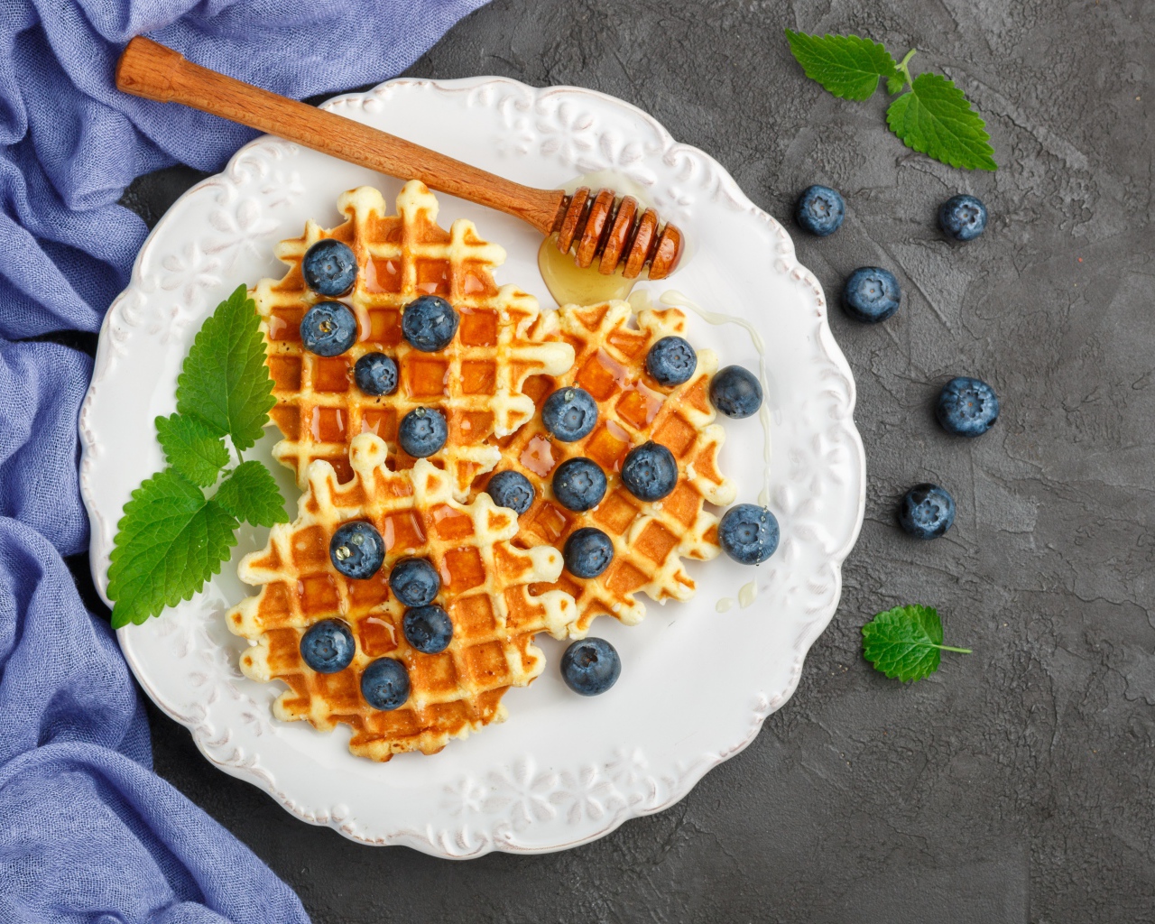 Сладкие вафли с медом на тарелке с ягодами черники