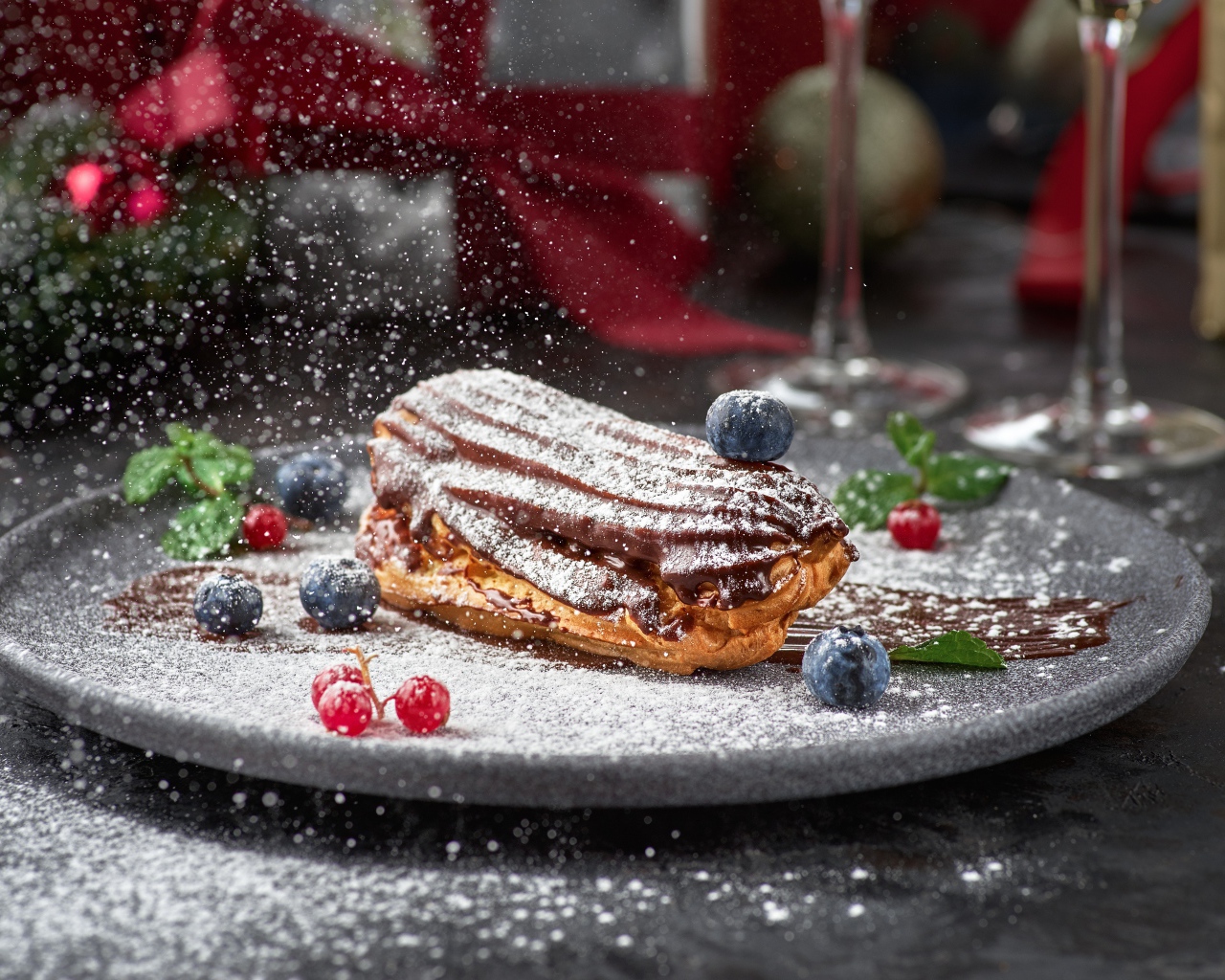 Вкусное пирожное на тарелке с сахарной пудрой и ягодами