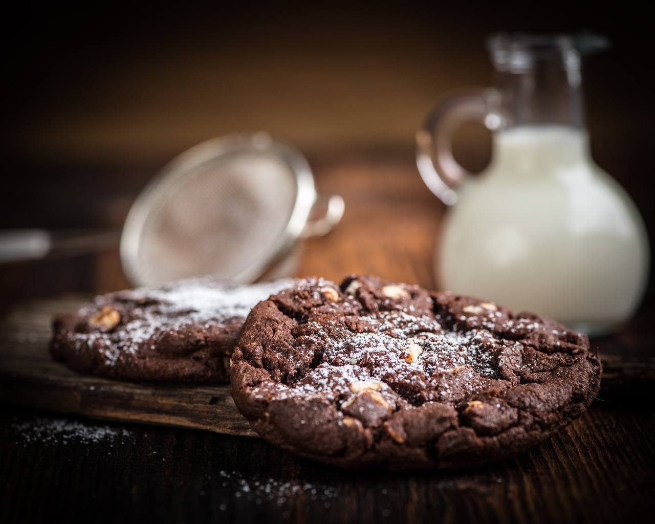 Вкусное шоколадное печенье с орехами на столе с молоком