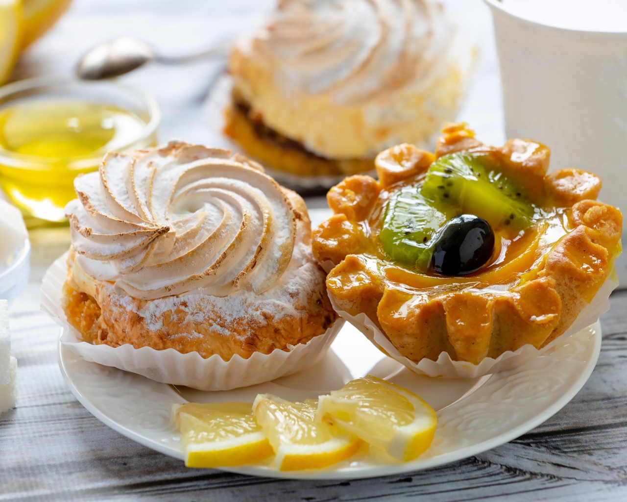 Вкусные аппетитные пирожные на тарелке с лимоном