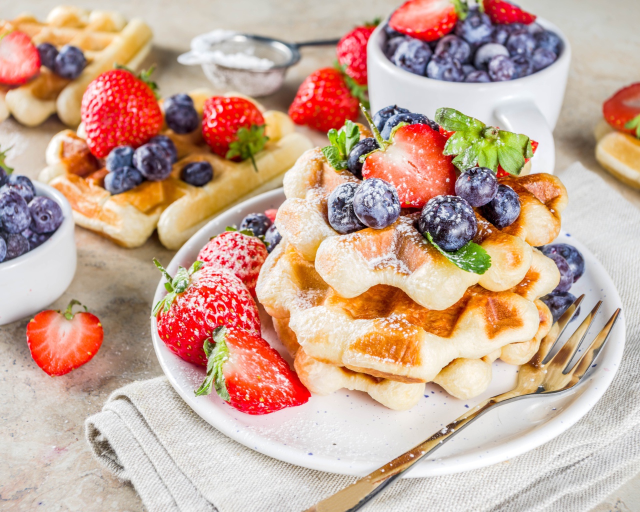 Вкусные сладкие вафли с ягодами клубники, черники и сахарной пудрой