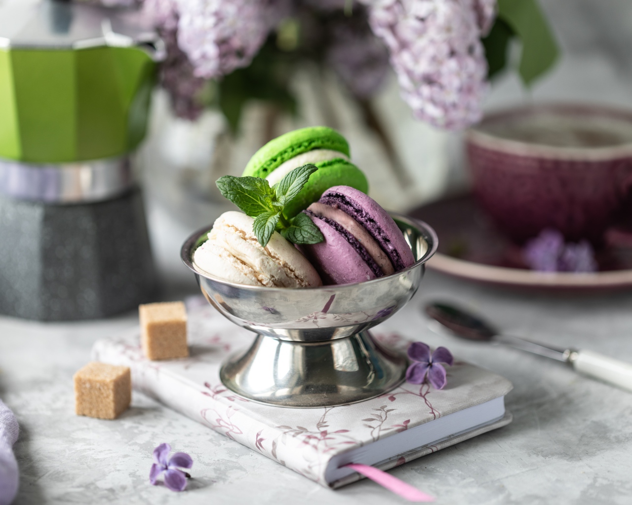 Три печенья макарун на столе с блокнотом