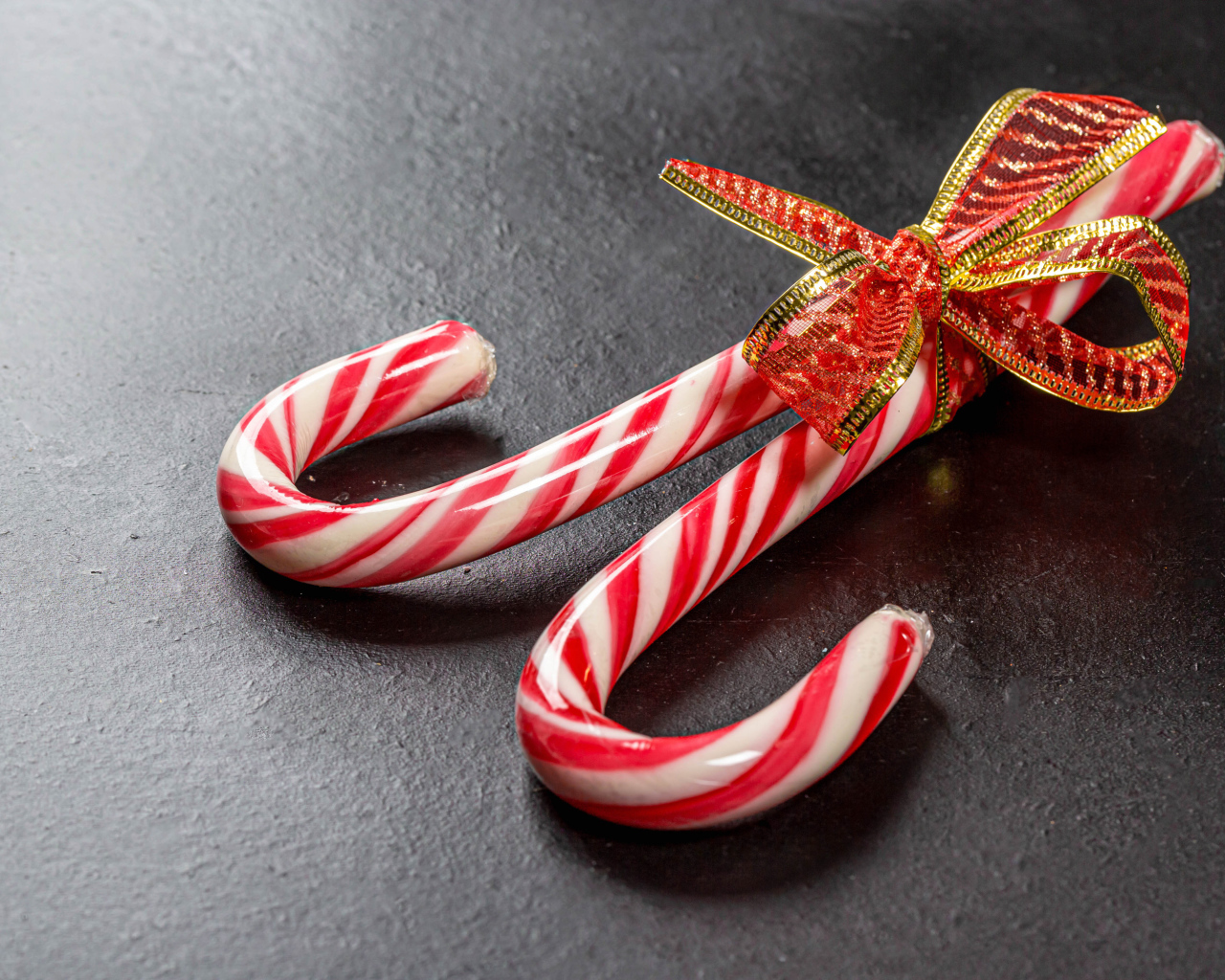 Два леденца перевязаны бантом на сером столе