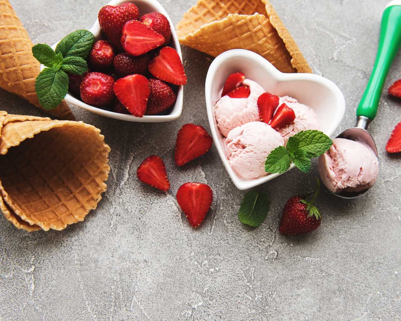 Вафельные рожки на столе с фруктовым мороженым и ягодами клубники 