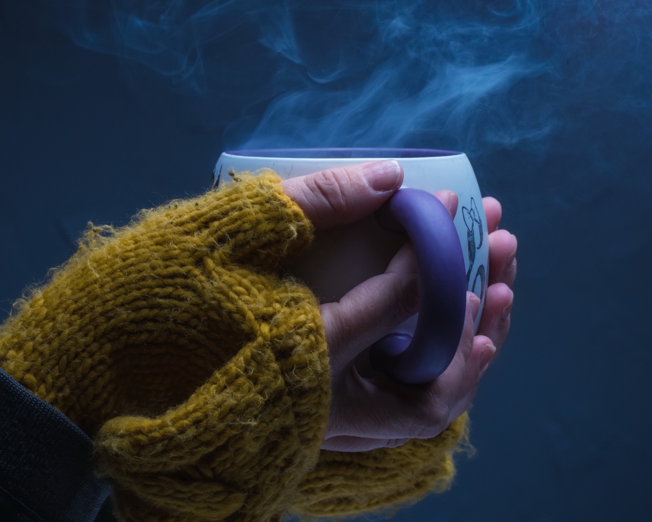 Чашка горячего кофе в руках у девушки на сером фоне