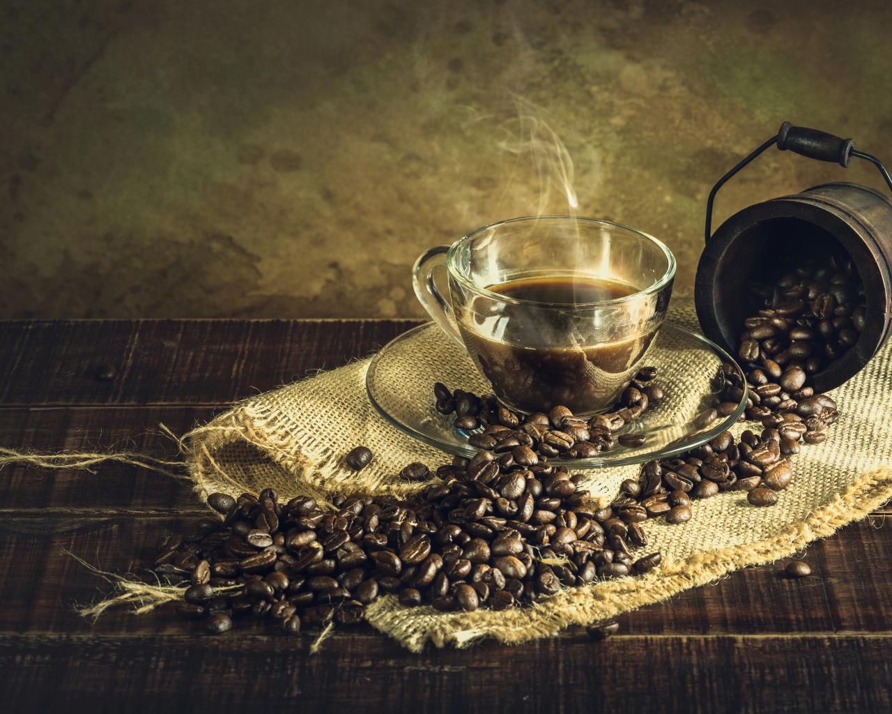 Чашка горячего крепкого кофе на столе с зернами