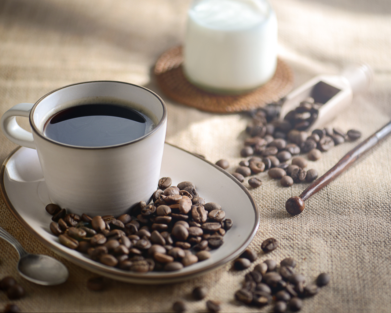 Чашка крепкого кофе на столе с зернами