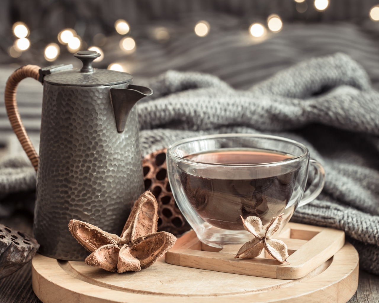 Чашка чая на столе с чайником и теплым пледом