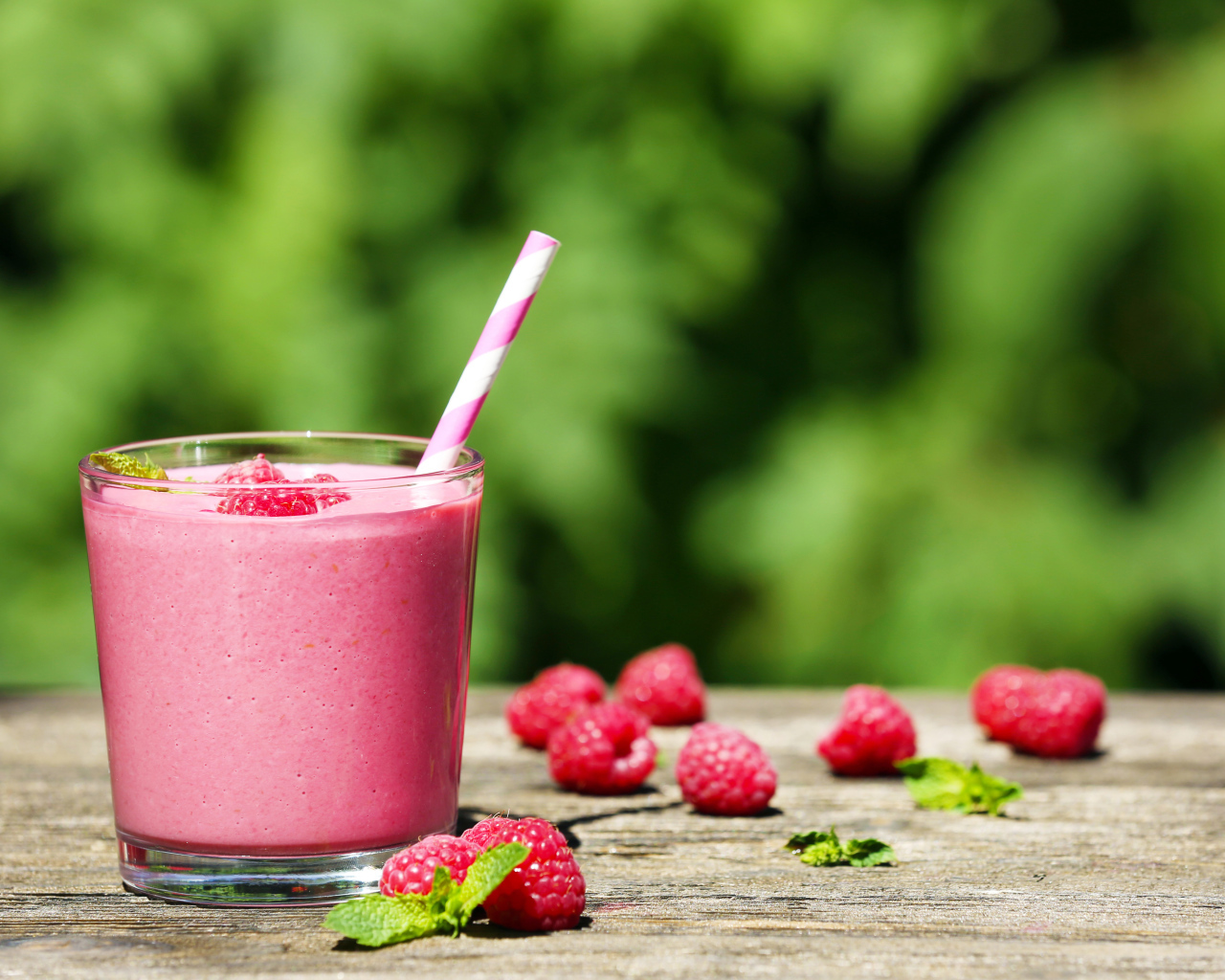 Коктейль в стакане с трубочкой и ягодами малины