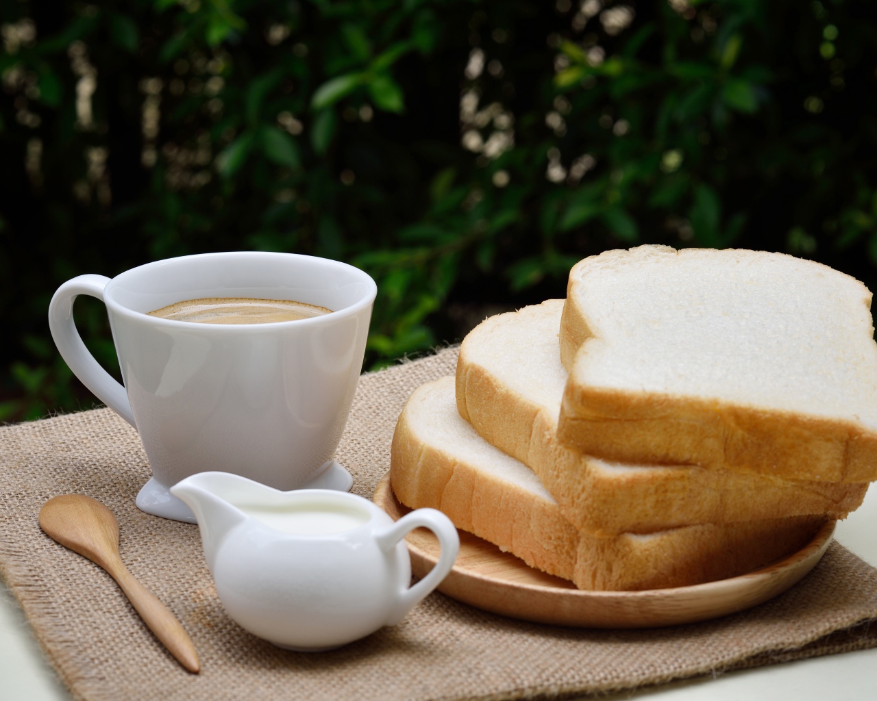 Кофе с молоком на столе с хлебом