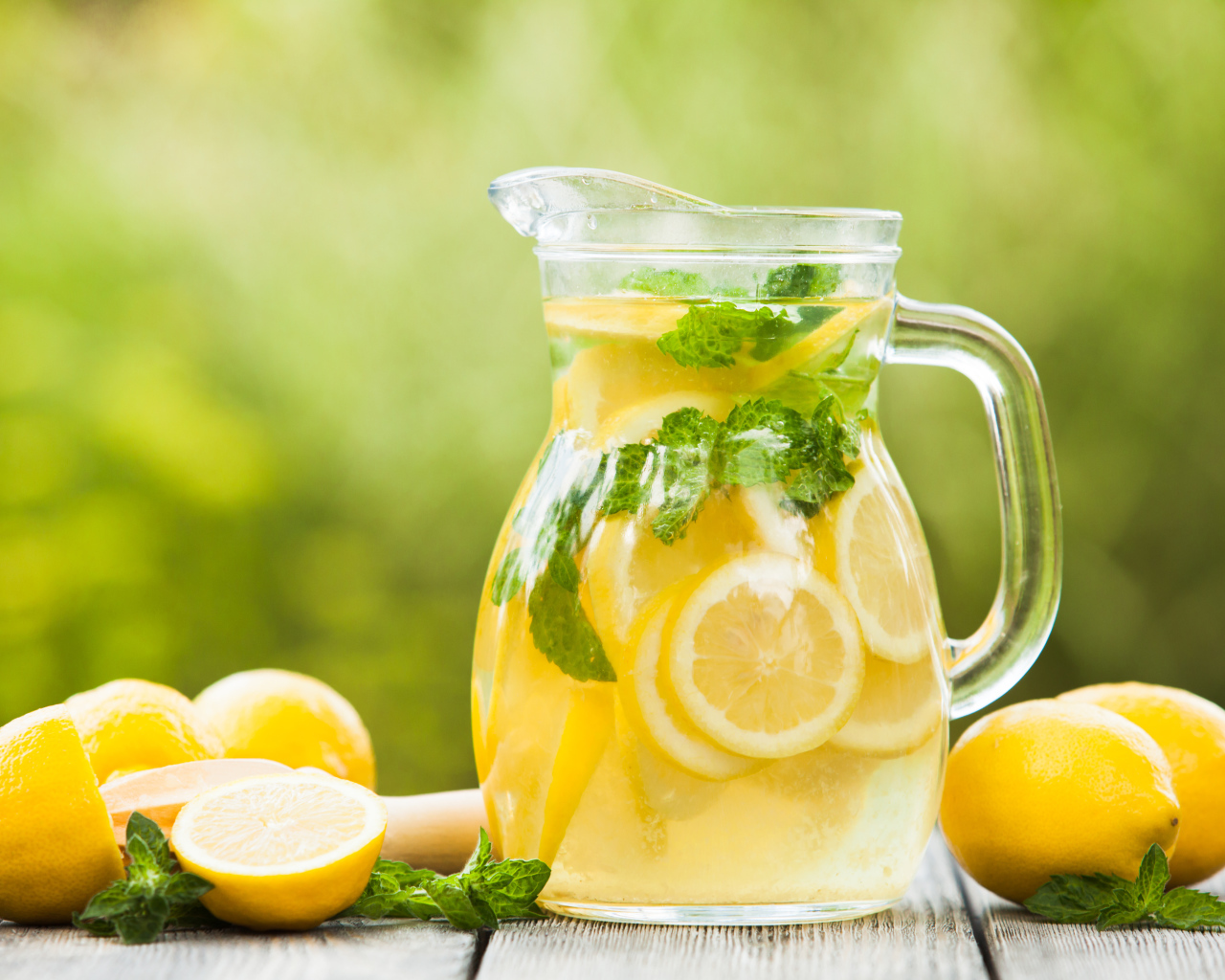 Лимонад в графине на столе с лимонами