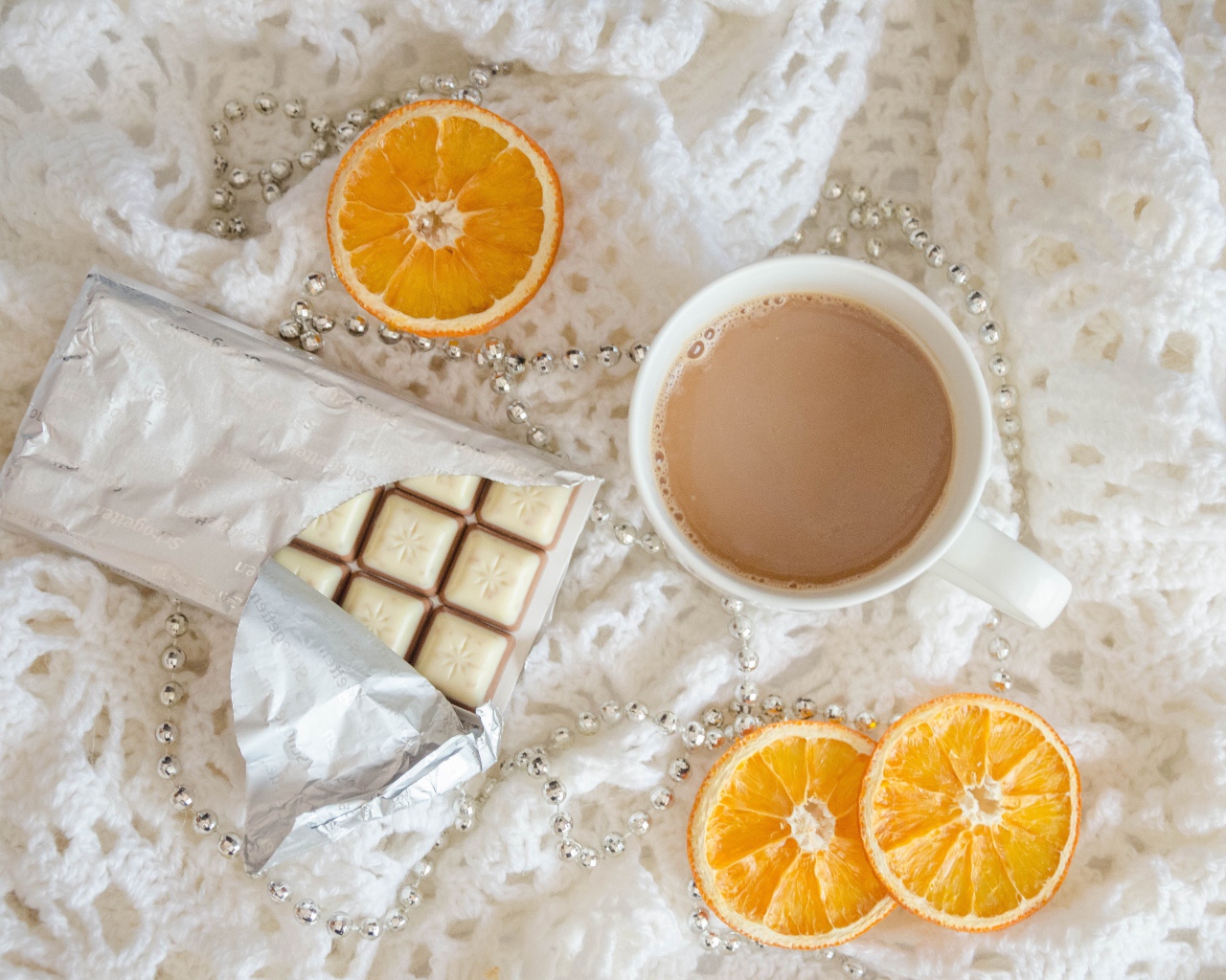 Чашка какао, шоколад и апельсин на белом пледе