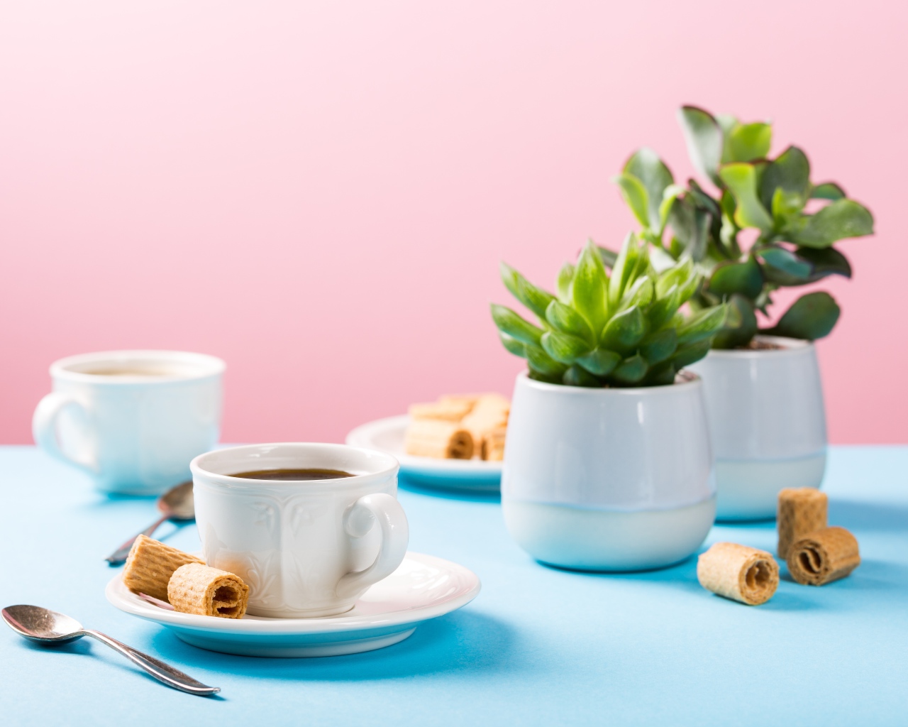 Чашка кофе на блюдце с вафлями на столе с цветами