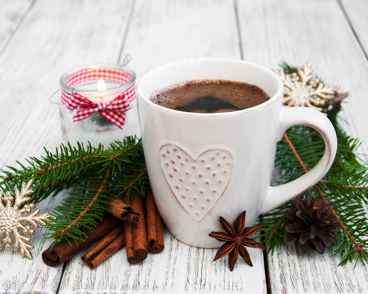 Чашка кофе на столе с еловой веткой, корицей и свечой