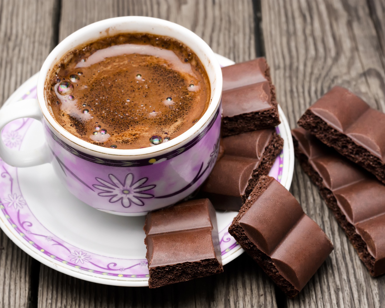 Чашка кофе на столе с кусочками шоколада