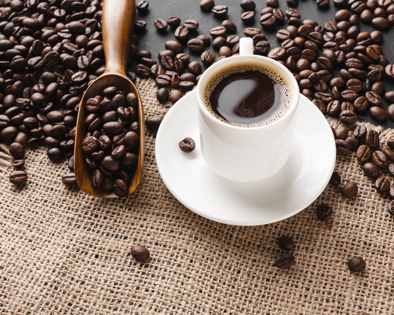 Чашка кофе на столе с зернами 