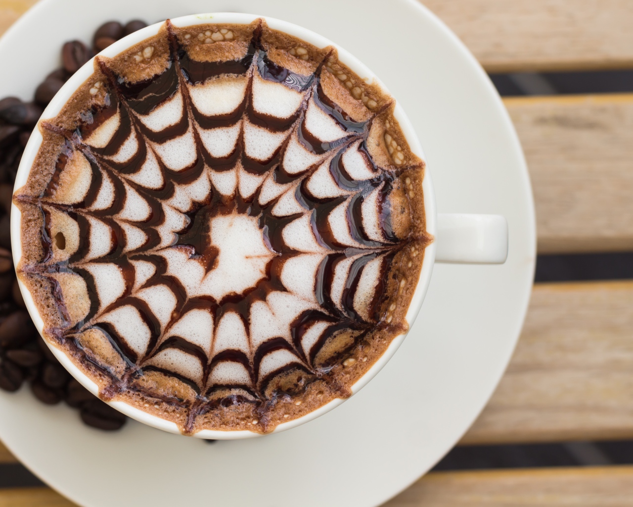 Чашка кофе с рисунком на пене на столе