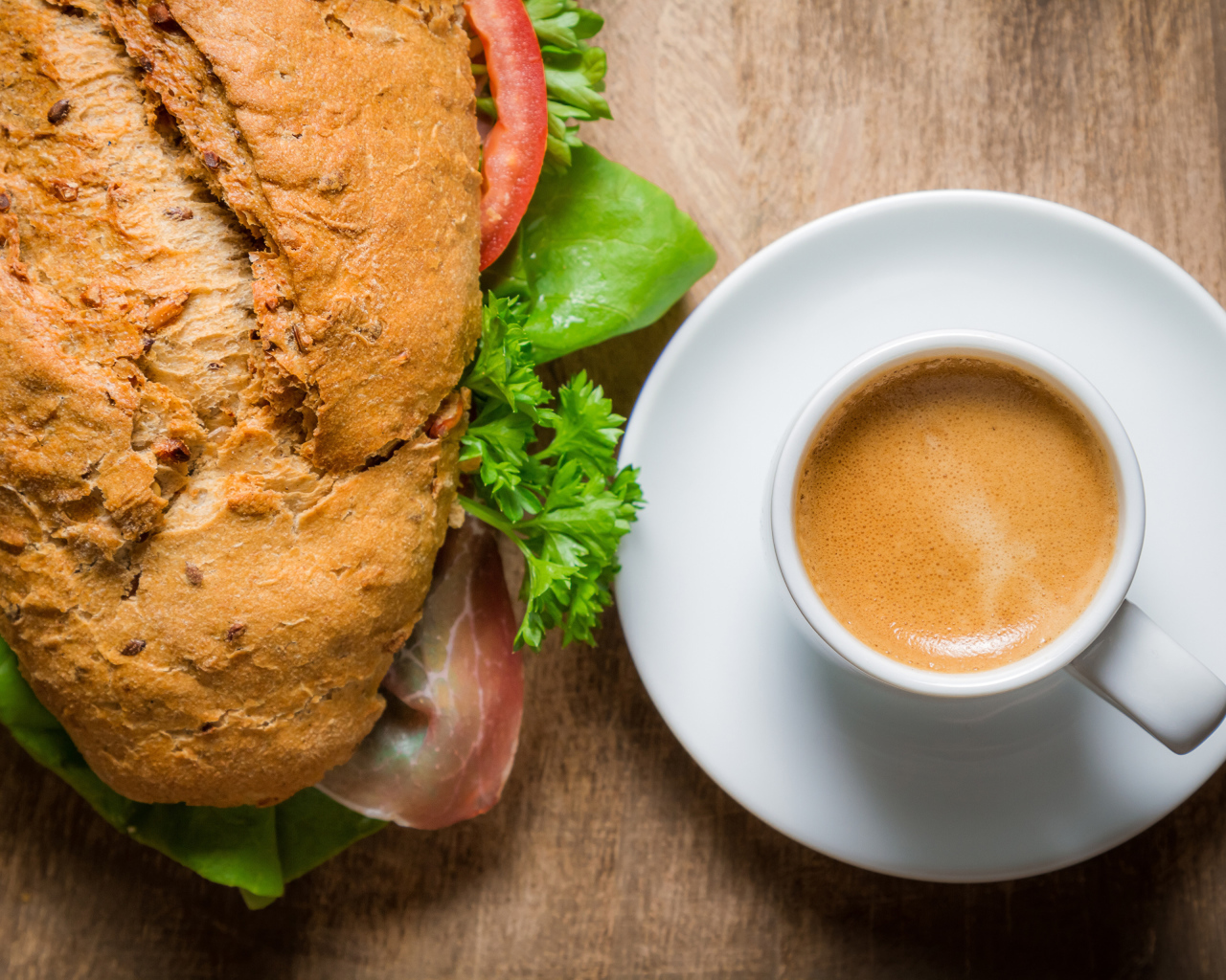 Чашка кофе с бутербродом на столе к завтраку 