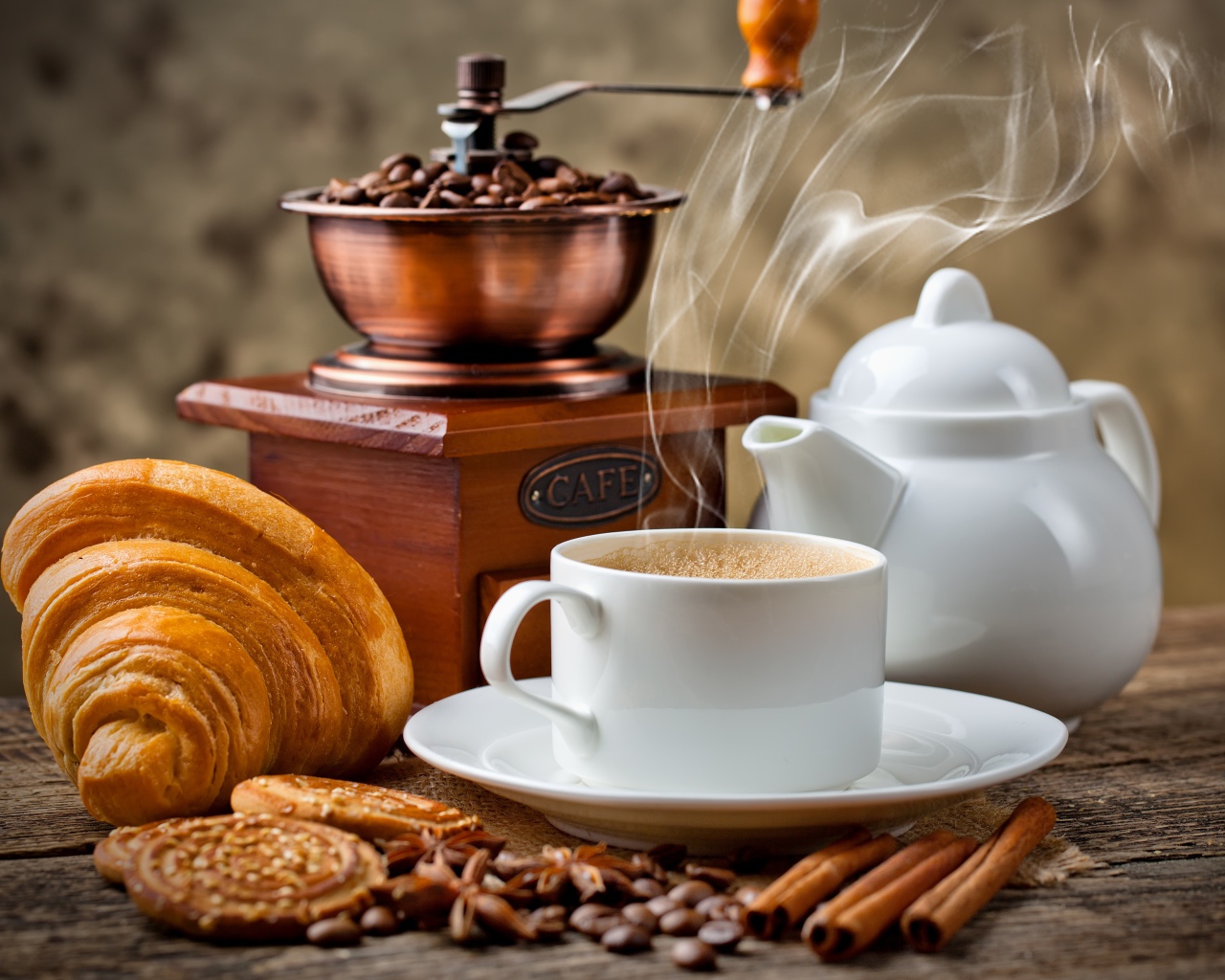 Чашка горячего ароматного кофе на столе с выпечкой и корицей 