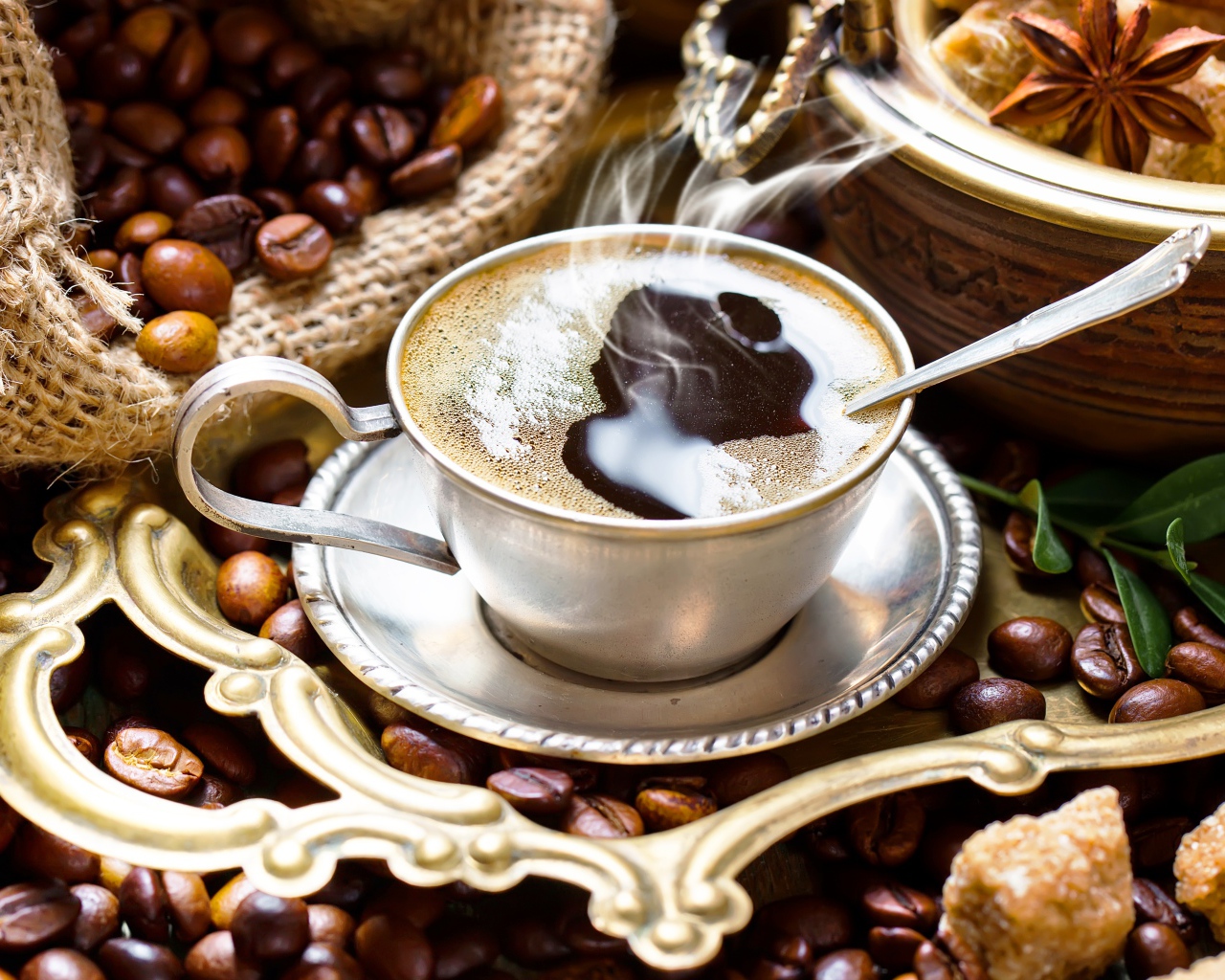 Чашка горячего вкусного кофе на столе с зернами